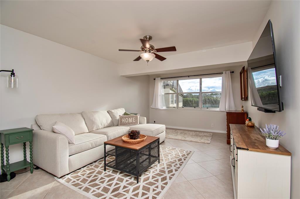 9500 Southwest 3rd Street, Unit 248 Boca Raton, FL 33428 - Photo 3 of 47 a living room with furniture a flat screen tv and a large window