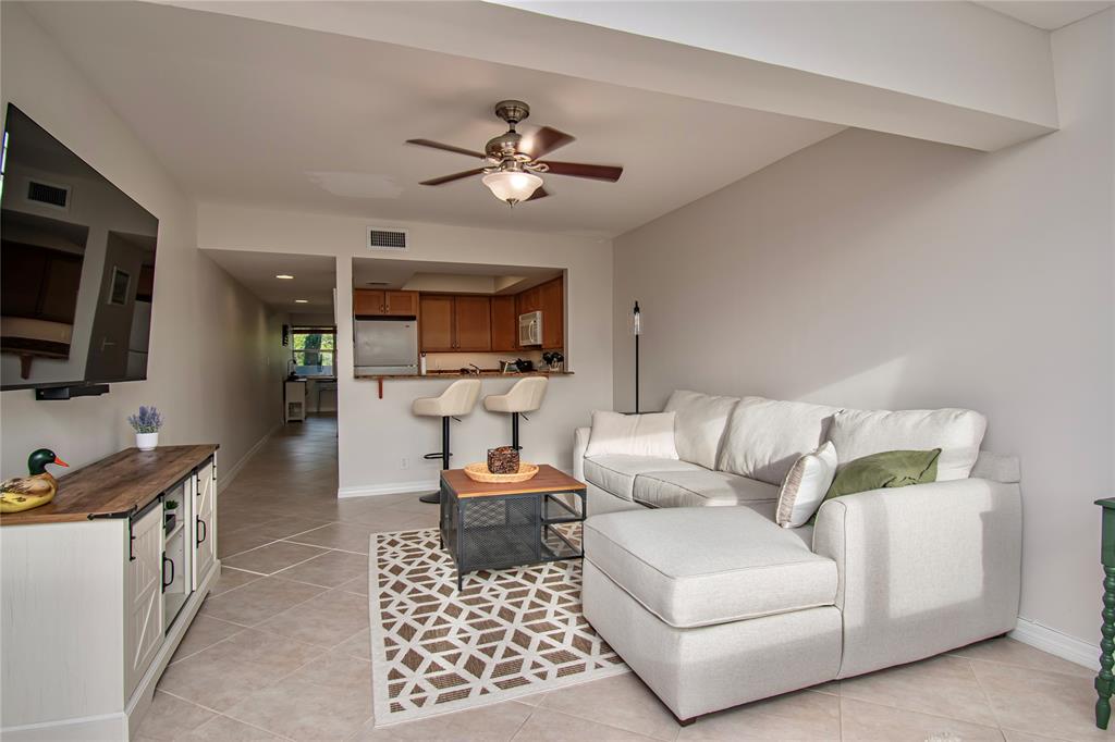9500 Southwest 3rd Street, Unit 248 Boca Raton, FL 33428 - Photo 10 of 47 a living room with furniture a flat screen tv and kitchen view