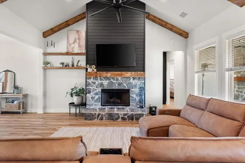a living room with furniture a fireplace and a flat screen tv