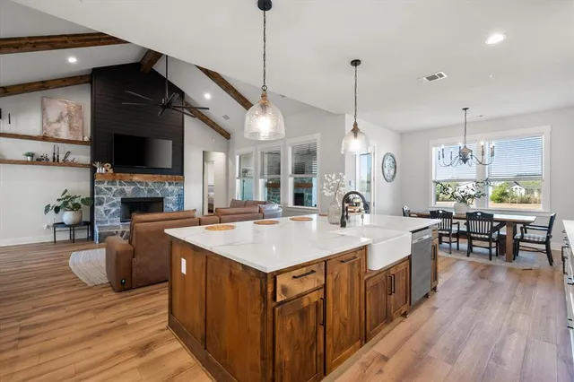 a kitchen with kitchen island granite countertop a sink a counter space appliances and cabinets