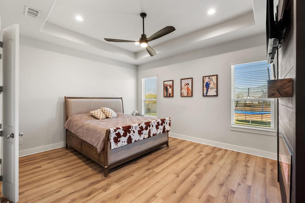 8221 David Lane Midlothian, TX 76065 - Photo 19 of 34 Bedroom with a raised ceiling, light wood-style flooring, a ceiling fan, and recessed lighting