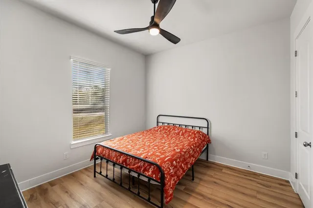 a bedroom with a bed wooden floor and window