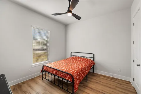 a bedroom with a bed wooden floor and window