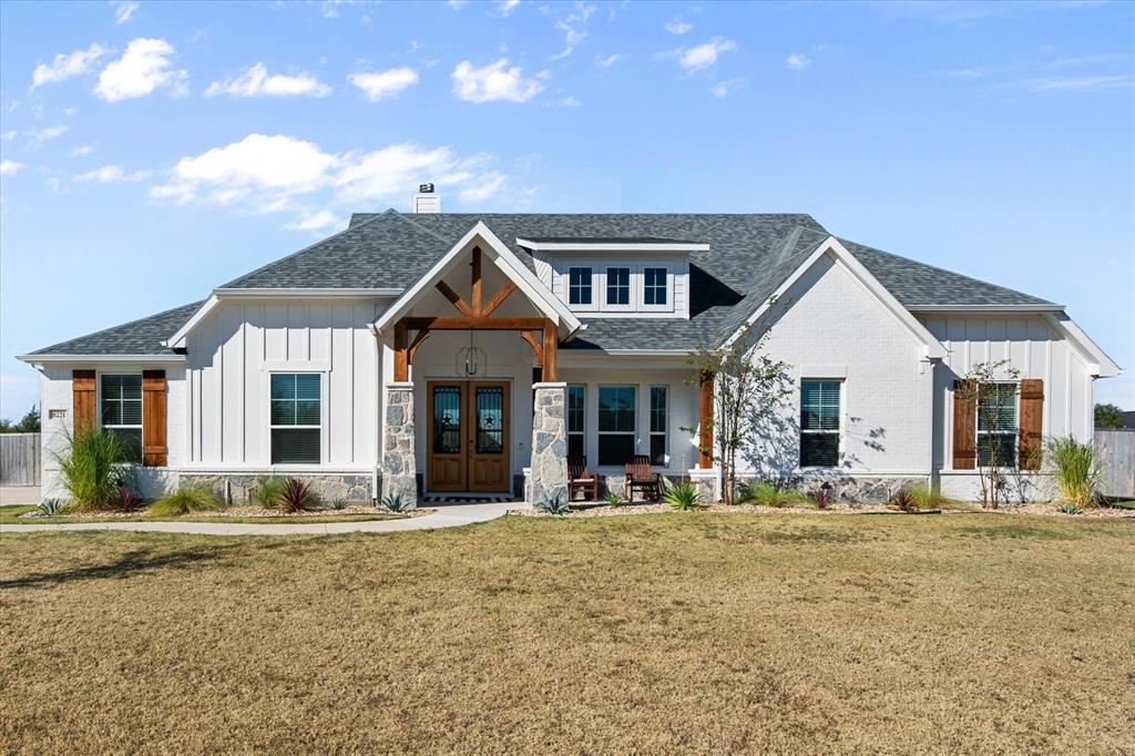 8221 David Lane Midlothian, TX 76065 - Photo 27 of 34 Modern farmhouse featuring board and batten siding, a shingled roof, a porch, a chimney, and stone siding