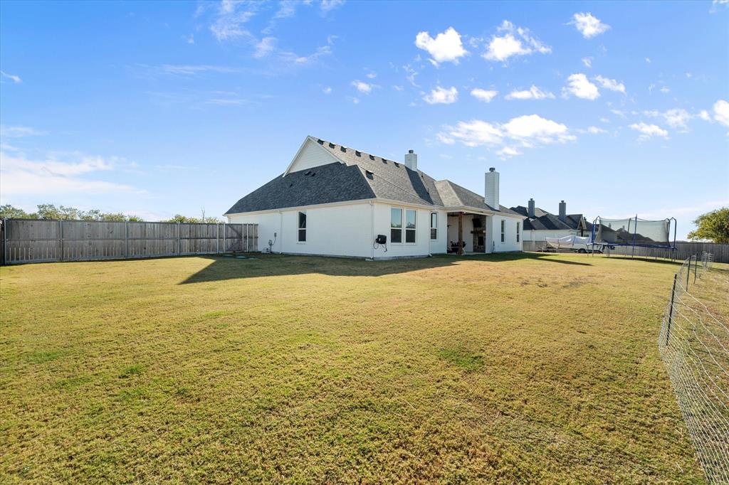 8221 David Lane Midlothian, TX 76065 - Photo 29 of 34 Rear view of property with a fenced backyard, a chimney, a trampoline, a patio, and a shingled roof