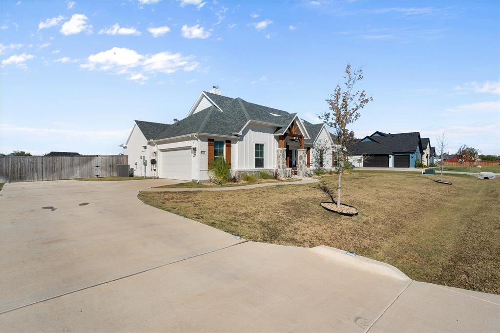 8221 David Lane Midlothian, TX 76065 - Photo 31 of 34 Modern farmhouse featuring board and batten siding, driveway, a chimney, a garage, and a shingled roof