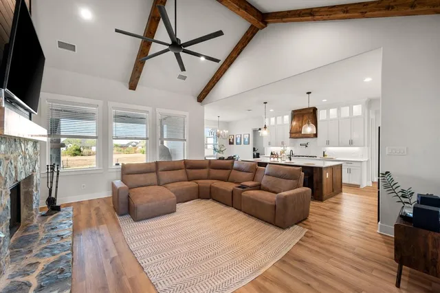 a living room with furniture a flat screen tv and a fireplace