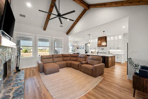 a living room with furniture a flat screen tv and a fireplace
