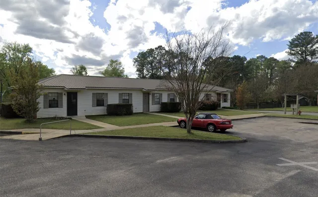 a view of a house with backyard and trees