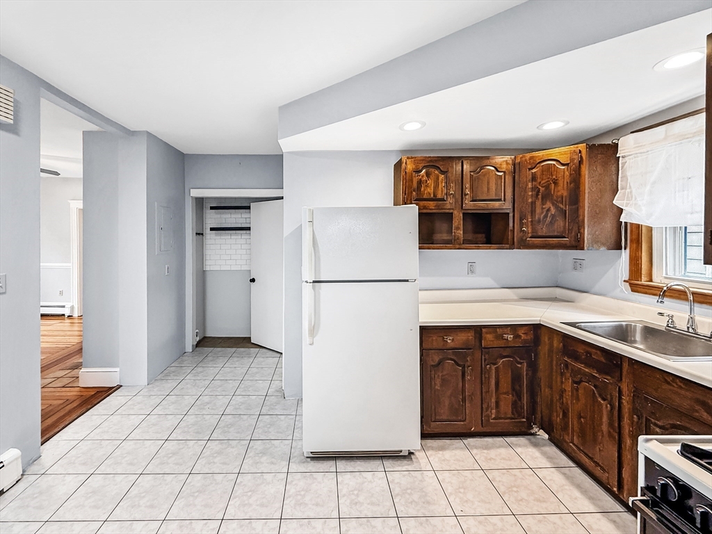 19 Moore Street Winthrop, MA 02152 - Photo 17 of 42 a kitchen with a sink a refrigerator and cabinets