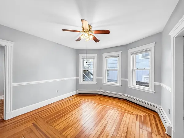 wooden floor fireplace and windows in an empty room