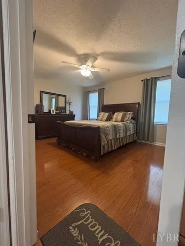a living room with a bed furniture and a ceiling fan