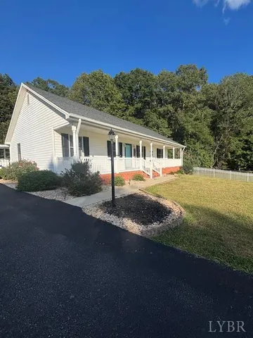 a front view of a house with a yard and lake view