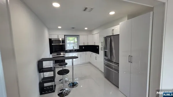 a kitchen with stainless steel appliances granite countertop a refrigerator and a stove top oven