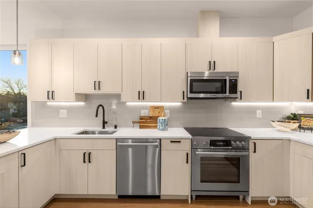 a kitchen with stainless steel appliances a sink a stove and a microwave