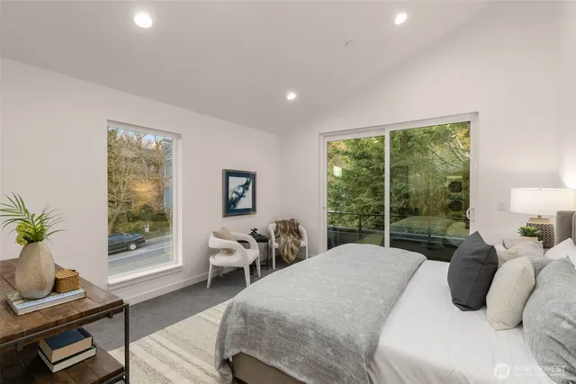 a bedroom with a bed and large windows