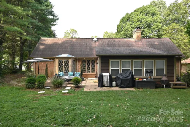 a view of house with yard and outdoor seating