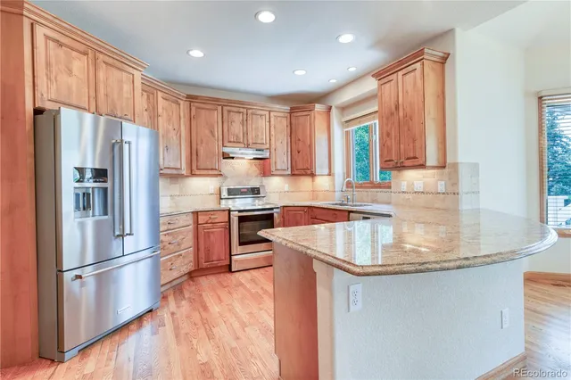 a kitchen with kitchen island granite countertop a sink appliances cabinets and counter space