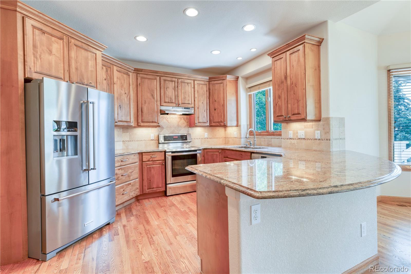 3756 West 100th Avenue Westminster, CO 80031 - Photo 13 of 45 a kitchen with kitchen island granite countertop a sink appliances cabinets and counter space