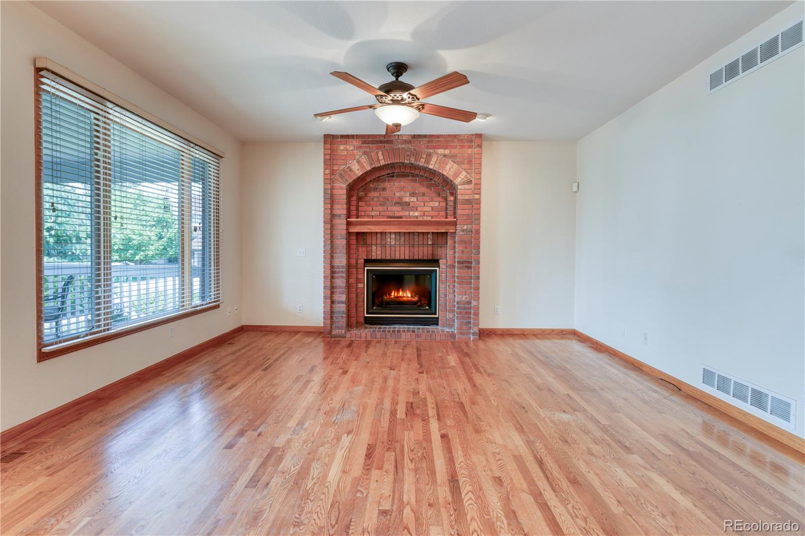 3756 West 100th Avenue Westminster, CO 80031 - Photo 18 of 45 a view of an empty room with wooden floor fireplace and a window