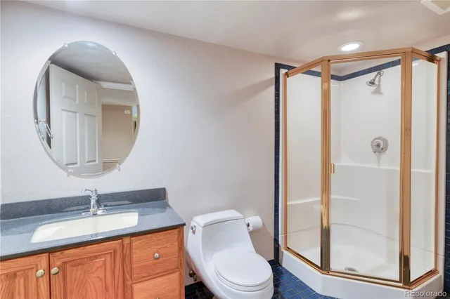 a bathroom with a granite countertop sink toilet mirror and shower