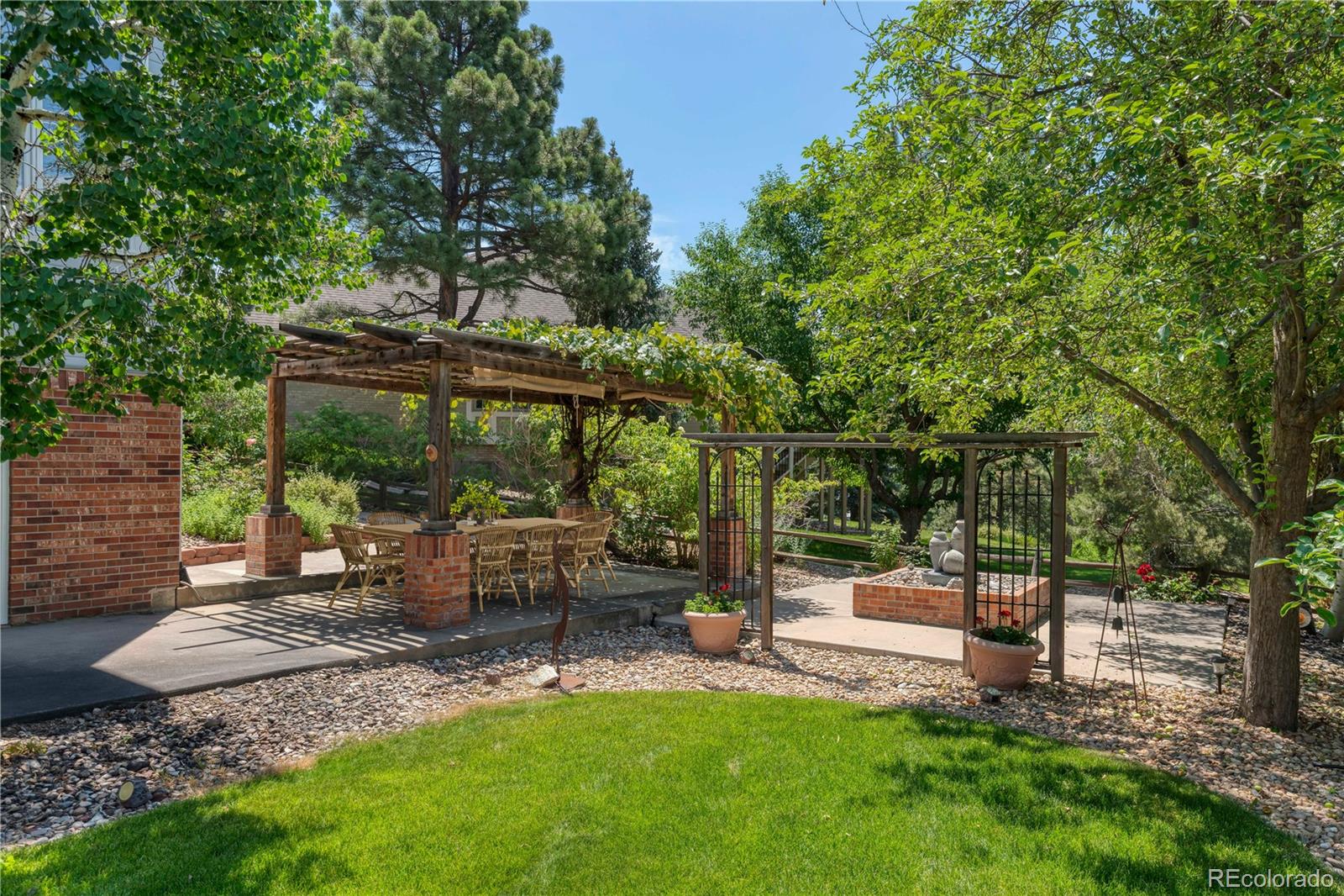 3756 West 100th Avenue Westminster, CO 80031 - Photo 40 of 45 a view of backyard with table and chairs a fire pit and large trees
