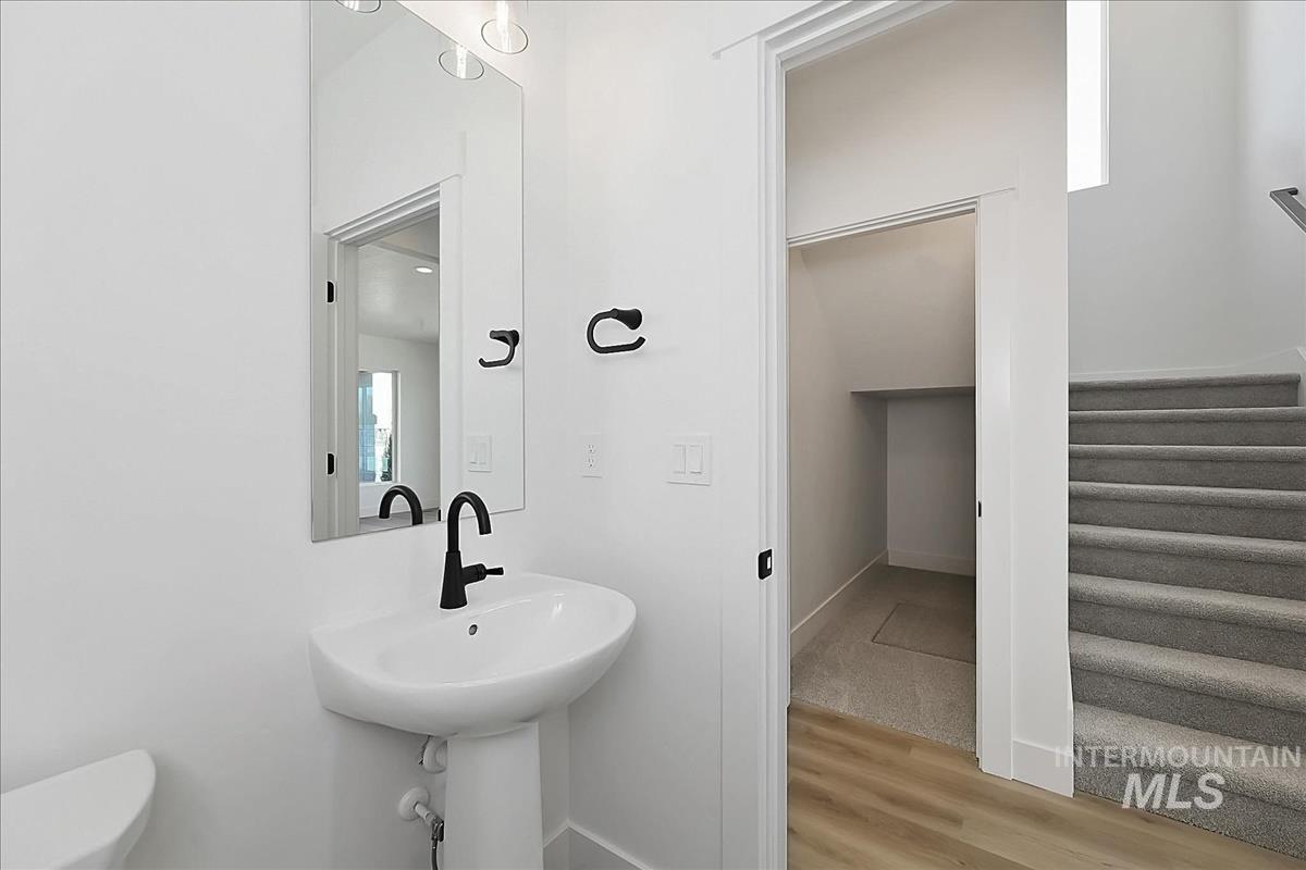 776 South Calhoun Lane Star, ID 83669 - Photo 36 of 49 Pedestal sink with matte black faucet, rectangular mirror with integrated lighting, and white walls