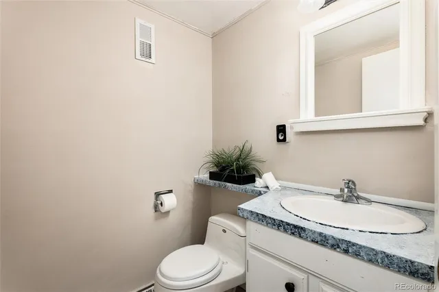 a bathroom with a granite countertop toilet sink and mirror