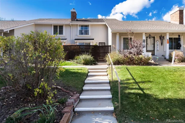 a front view of a house with a yard and potted plants