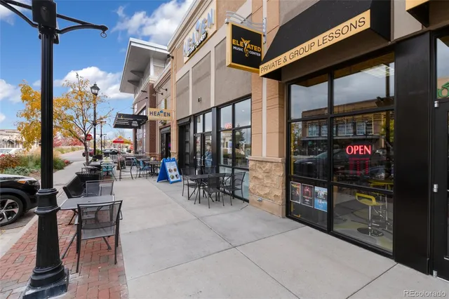 a front view of a building with garden and street view