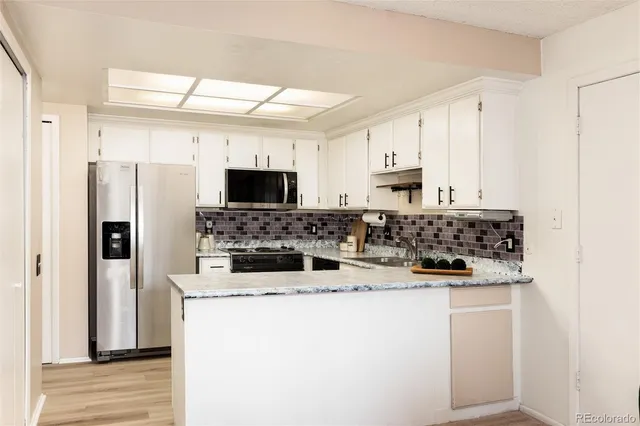 a kitchen with kitchen island a white cabinets and refrigerator