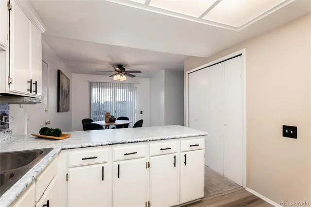 a kitchen with granite countertop a sink cabinets and a wooden floor
