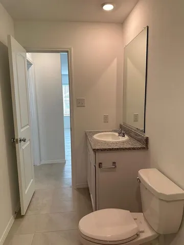 a bathroom with a toilet a sink and a mirror