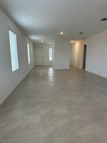 an empty room with windows and entrance to other room