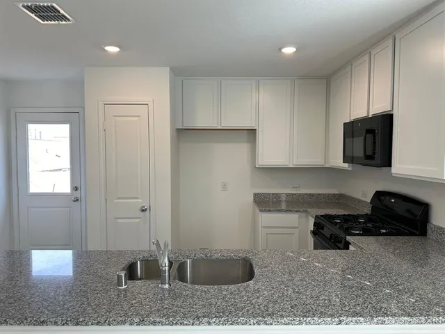 a kitchen with stainless steel appliances granite countertop a sink and a granite counter tops