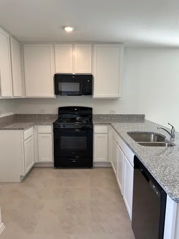a kitchen with granite countertop a sink and cabinets