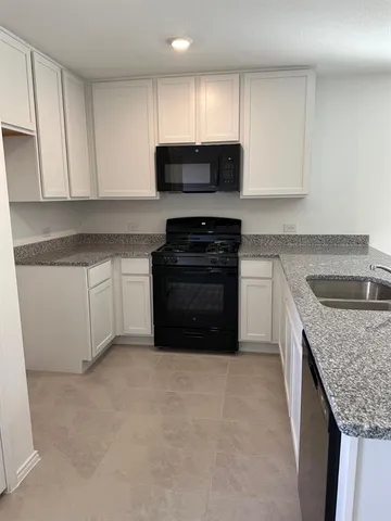 a kitchen with granite countertop a sink and a stove