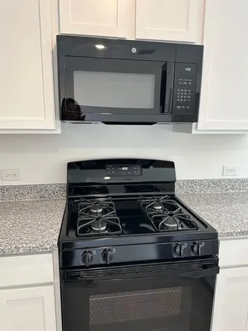 a stove top oven sitting inside of a kitchen