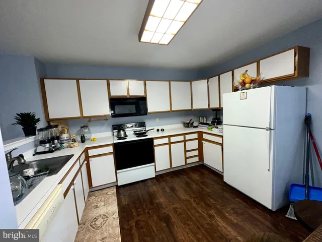 a view of a dining room with furniture a chandelier and wooden floor