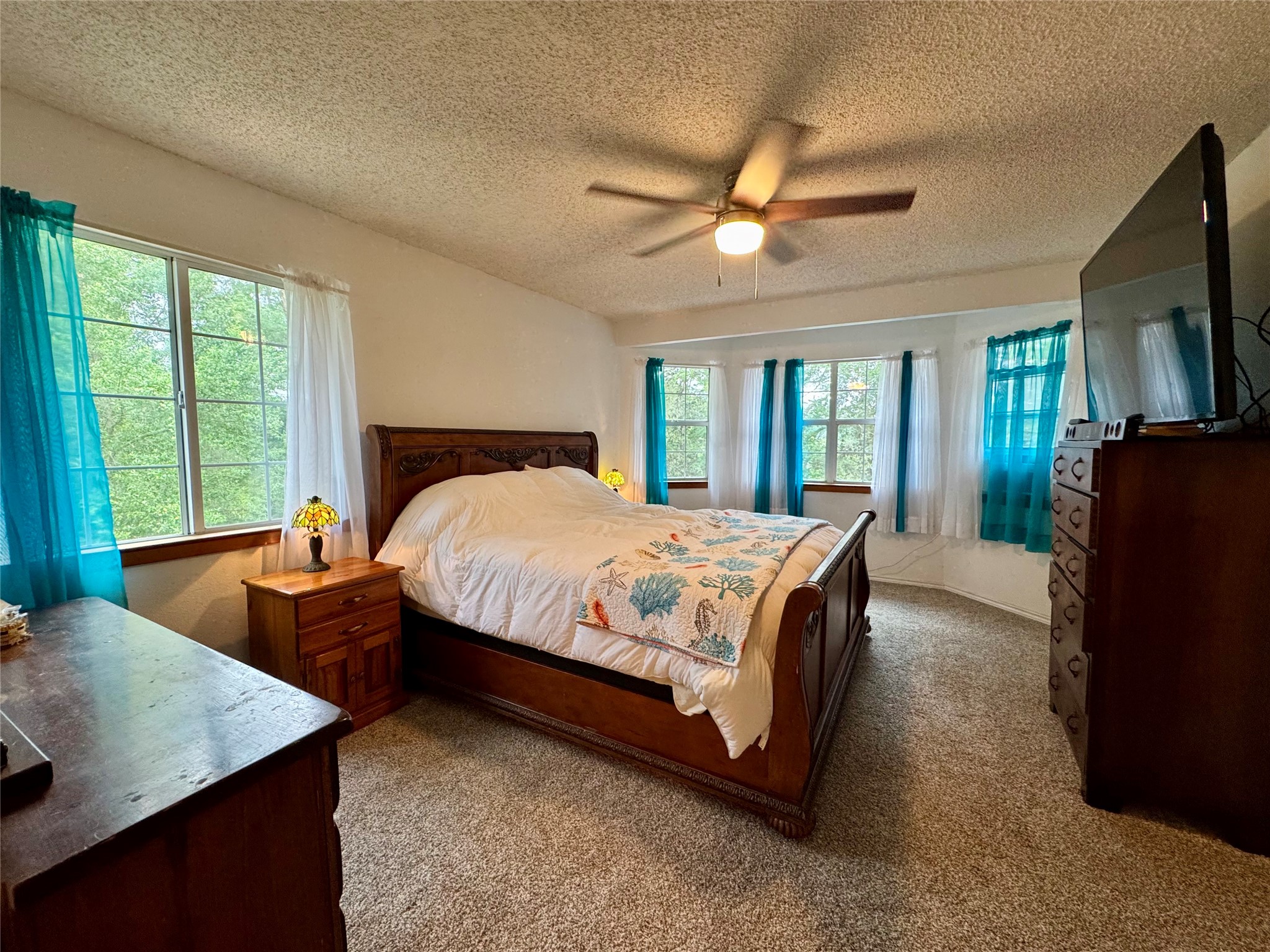 954 Hillbilly Heaven Road Livingston, TX 77351 - Photo 26 of 37 a spacious bedroom with a bed and a flat tv screen on dresser