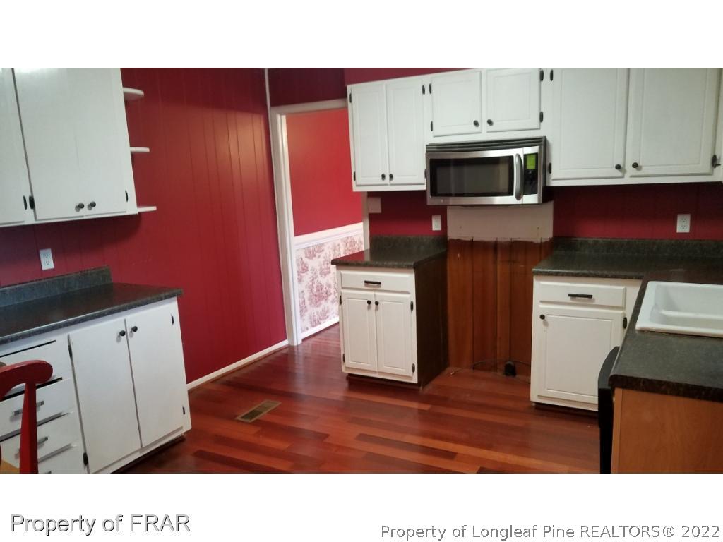 1817 Joel Road Carthage, NC 28327 - Photo 4 of 20 a kitchen with stainless steel appliances kitchen island granite countertop a stove a sink and a microwave
