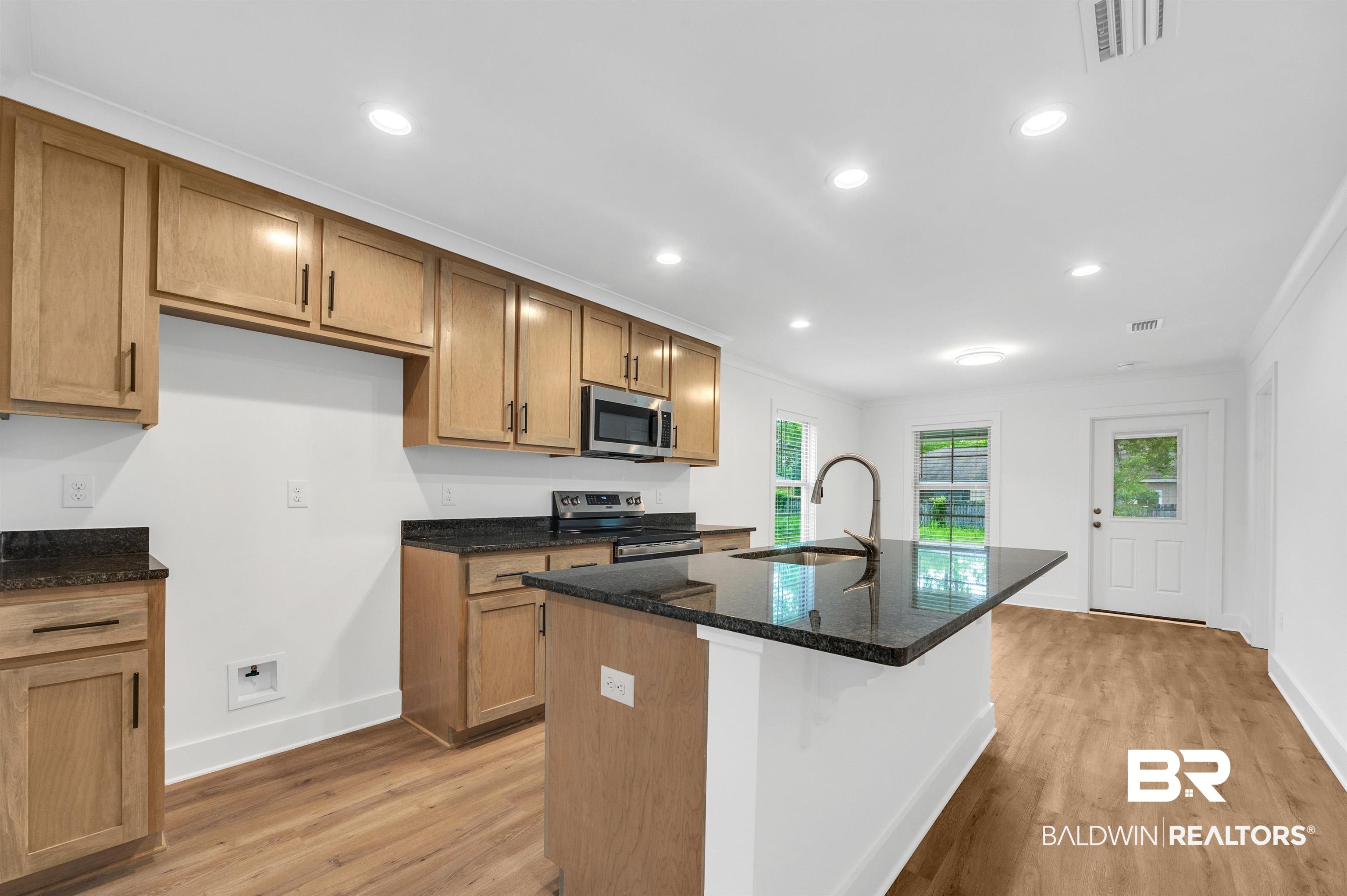 22045 8th Street Silverhill, AL 36576 - Photo 12 of 39 Kitchen with appliances with stainless steel finishes, a sink, light wood-style floors, baseboards, and ornamental molding