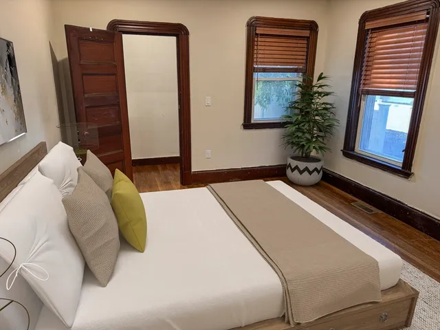 a bedroom with bed and wooden floor