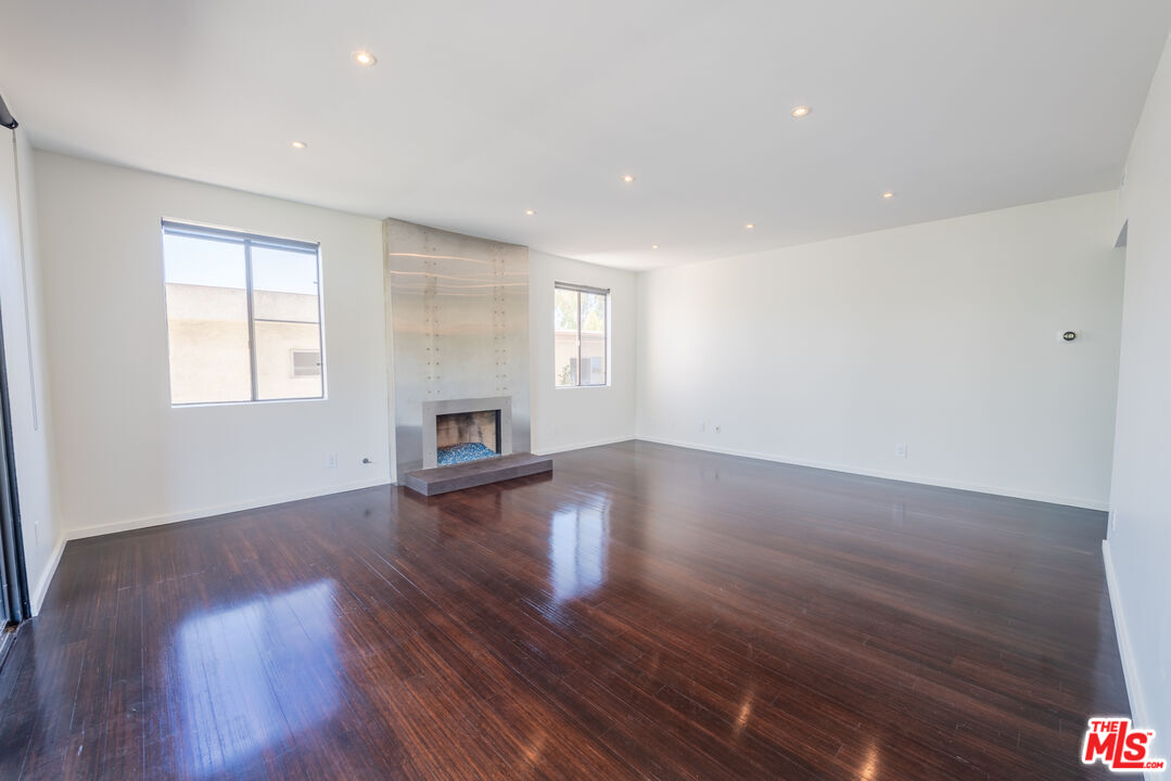1505 Purdue Avenue, Unit 202 Los Angeles, CA 90025 - Photo 2 of 14 a view of empty room with wooden floor and fireplace