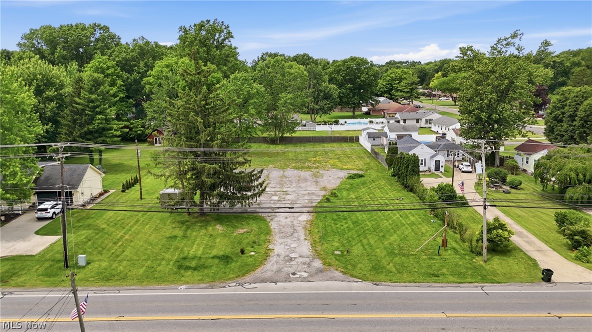 7474 Avon Belden Road North Ridgeville, OH 44039 - Photo 1 of 6 Expansive lot with mature trees, a partially paved driveway, and manicured green spaces