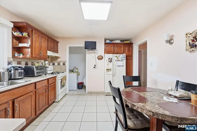 a open kitchen with stainless steel appliances granite countertop a stove a refrigerator a sink dishwasher with a dining table and chairs