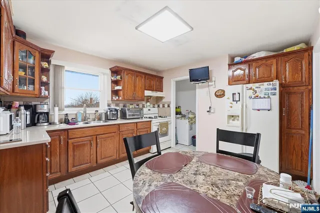 a large kitchen with stainless steel appliances granite countertop a refrigerator and a stove top oven
