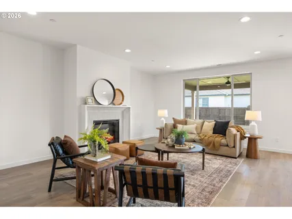 a living room with furniture a fireplace and a floor to ceiling window