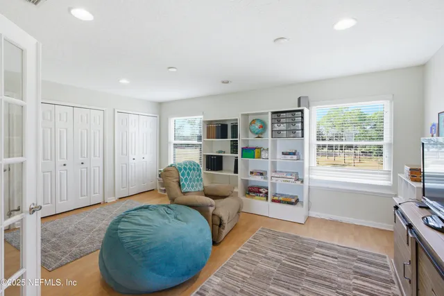 a room with stainless steel appliances a dining table wooden floor and a window