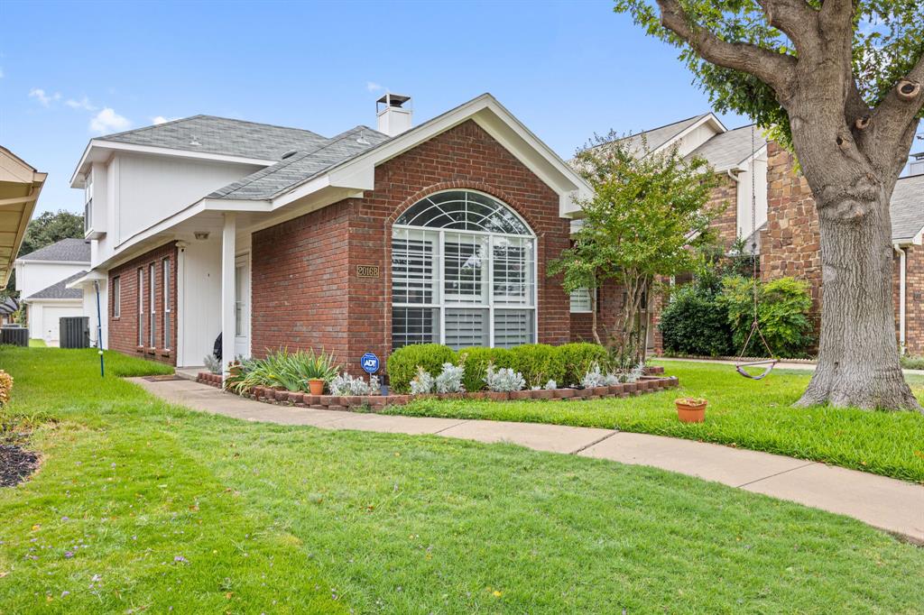 2016 Falcon Ridge Drive, Unit B Carrollton, TX 75010 - Photo 1 of 11 Single story home with brick siding, a front yard, a shingled roof, and a chimney
